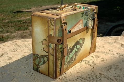 An Old Suitcase Sitting On Top Of A Table In The Sun With Butterflies