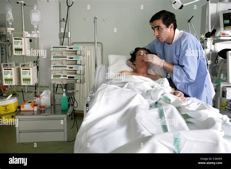 Male Nurse Taking Care Of Patient In An Hospital Bed Stock Photo Alamy