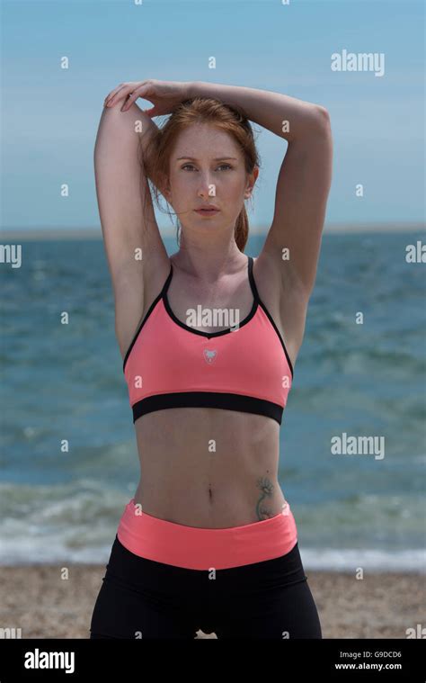 Woman Doing An Arm Stretch Wearing Sports Bra And Shorts Stock Photo