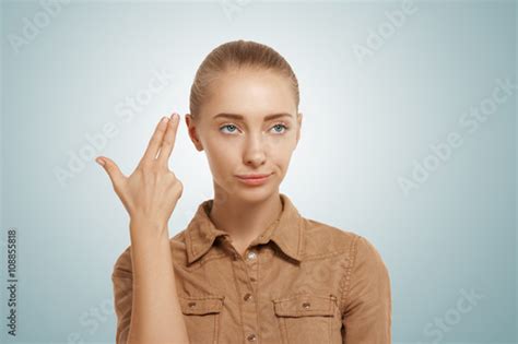 Isolated Headshot Of Young Woman Committing Suicide With Finger Gun