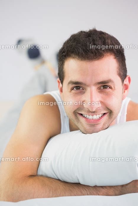 Cheerful Handsome Man Lying In Bed Looking At Camera In Bright Bedroom
