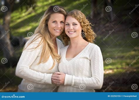 Pretty Mother Sitting On The Couch With Her Daughter Kissing Her Cheek Stock Image