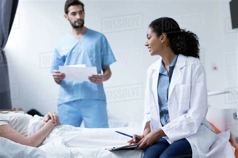 Doctors Consulting With Patient Stock Photo Dissolve