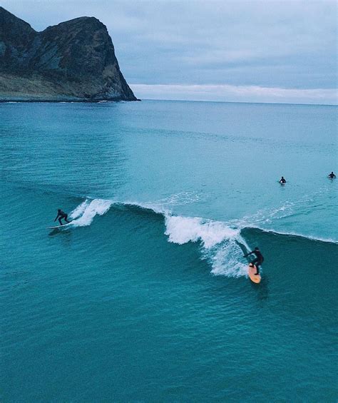 Three Surfers Are Riding The Waves On Their Surfboards In The Ocean