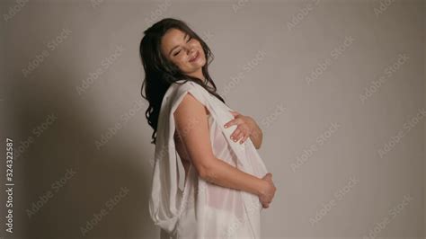 beautiful naked pregnant woman with white silk on white background pregnancy nude concept