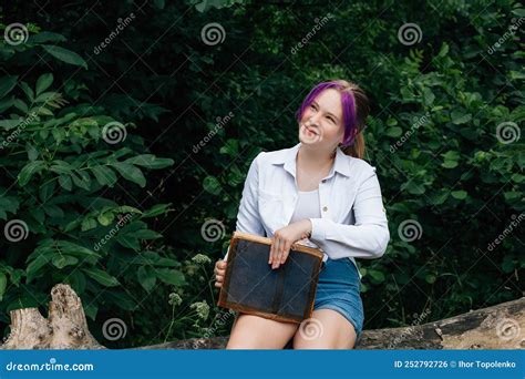 A Young Smiling Schoolgirl With Stylishly Dyed Hair With A Purple