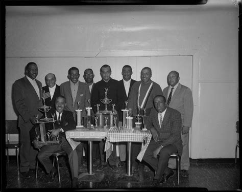 Group Portrait Of Ten Men Including Man Holding Large Trophy Gathered