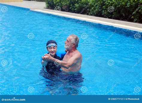 portrait asia senior woman and caucasian old man resting together in the edge of swimming pool
