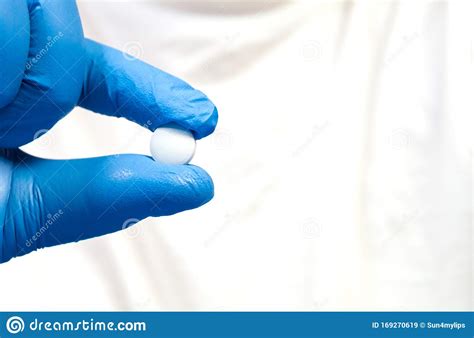 A Woman`s Hand In A Blue Latex Glove Holds A Pill Diseases Colds Flu