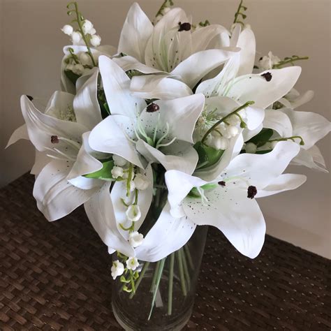 An Artificial Flower Arrangement Of Real Touch Lilies In Glass Cylinde