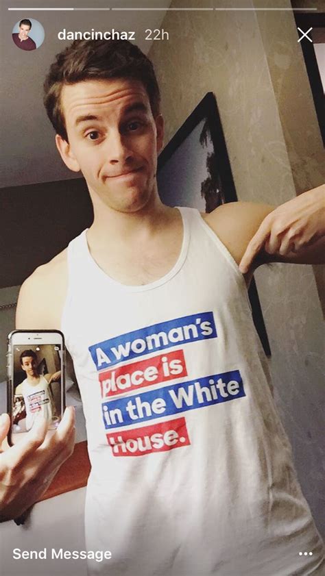 a man taking a selfie with his cell phone in front of him and wearing a white tank top that says