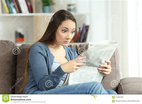Upset Woman Reading Surprising News In A Newspaper Stock ...