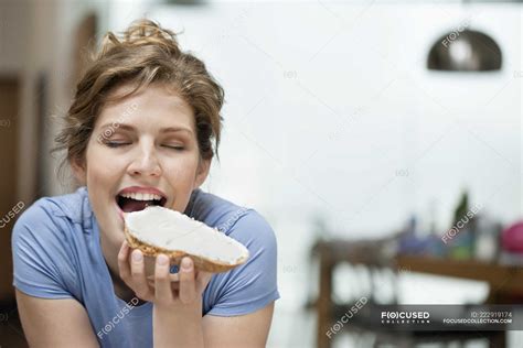 Portrait Of Young Woman Eating Toast With Cream Spread — Slice Of Bread