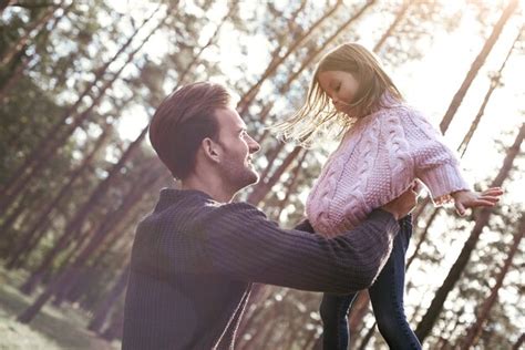 Маленькая девочка и ее отец в лесу девушка обнимает отца молодой человек в темном свитере