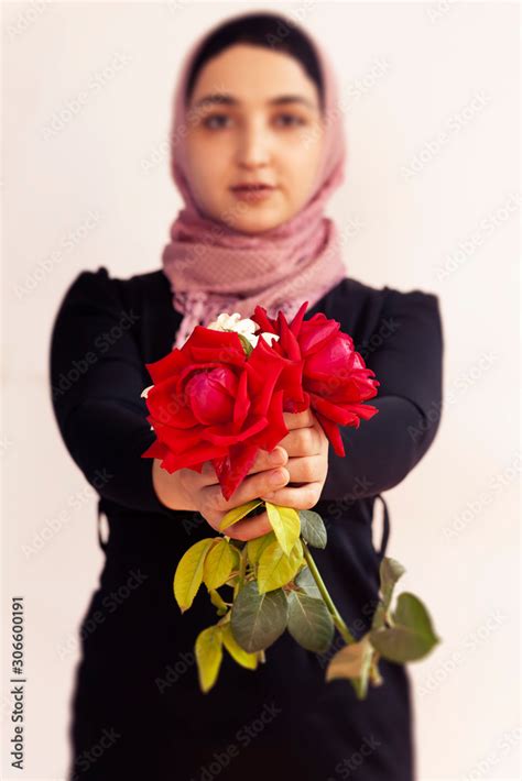 Stylish Muslim Woman In Traditional Islamic Clothing Holding Flower