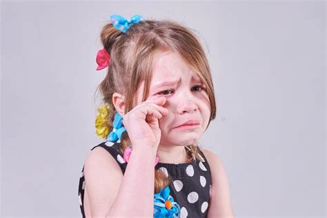 Une Belle Petite Fille Avec Une Expression Triste Pleure Et L Essuie Des Larmes Avec Ses Mains