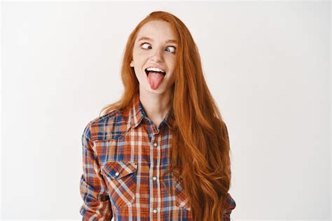 Premium Photo Funny Redhead Girl Showing Tongue And Squinting Making