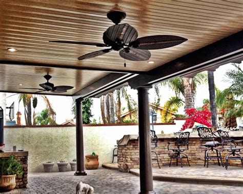 A Dog Is Standing In The Middle Of An Outdoor Patio With Ceiling Fans On It