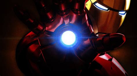 The Iron Man Is Holding His Hand Out With Glowing Light In Its Center