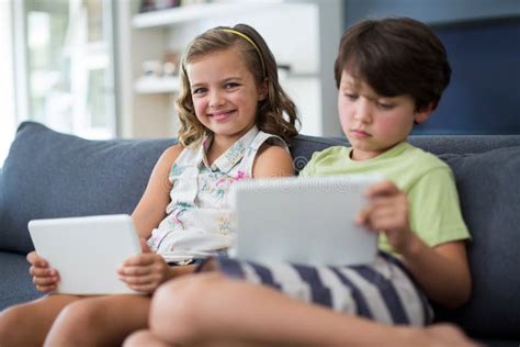 Siblings Using Digital Tablet In Living Room Stock Image Image Of Home Life 91760385