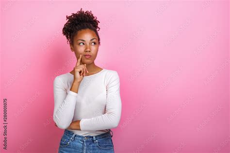Studio Portrait Of A Thinking Pose Girl Touching Herself Face By Index