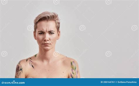Still Kind Of Miffed Portrait Of Dissatisfied Half Naked Tattooed Woman With Pierced Nose And