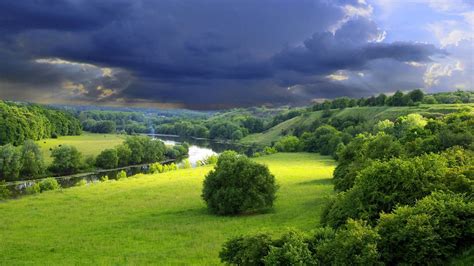 River Between Green Grass Field With Trees Under Cloudy Sky Hd Nature