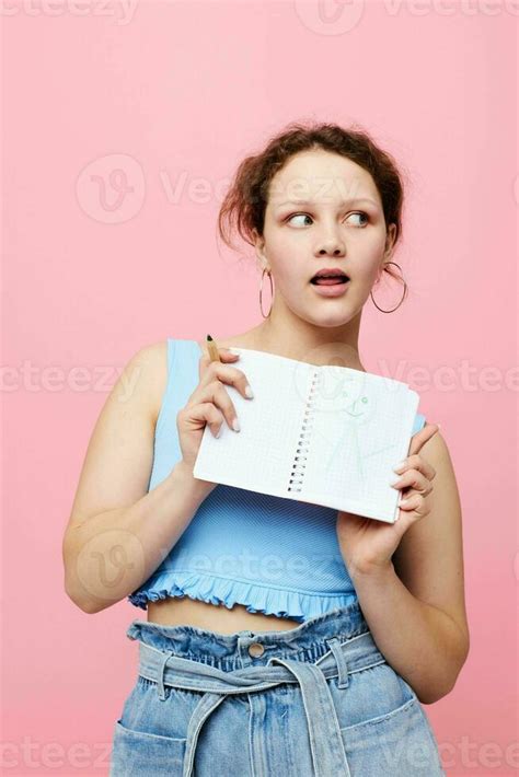 Teenager Girl Writing In A Red Notebook With A Pen Study Pink Color