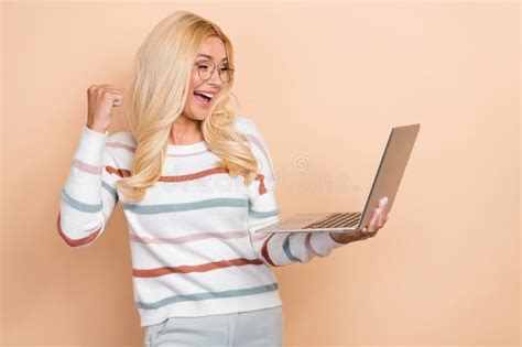 Photo Of Mature Age Woman Remote Worker Wear Striped Sweater Celebrate Fist Up Hold Laptop Final