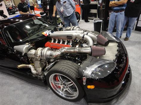 A Black Car With An Engine On Display At A Show Or Exhibition In Front
