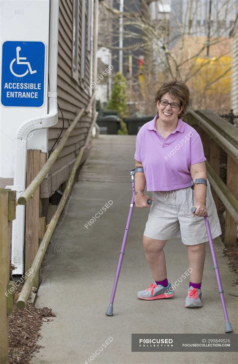 Woman With Cerebral Palsy Walking Down An Accessible Ramp Disability