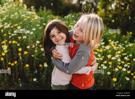 School Aged Boy And Girl Hugging In Field Of Flowers Stock Photo Alamy