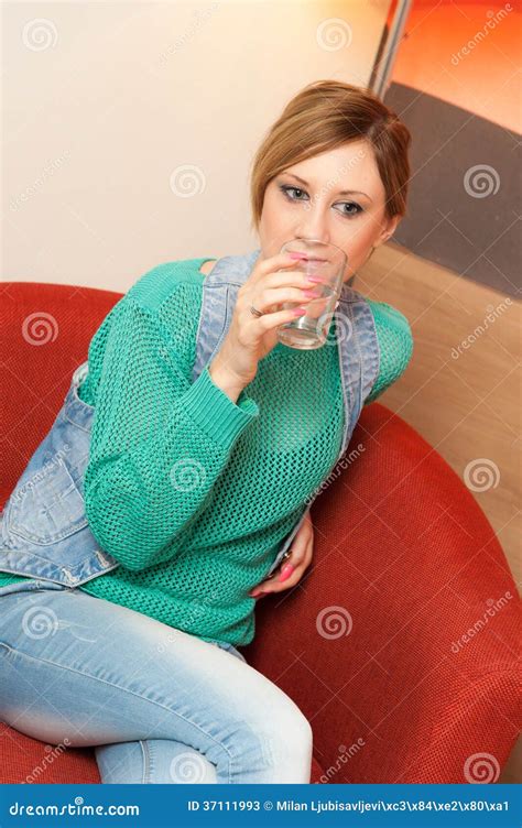 woman sitting on red chair drinking water stock image image of lifestyle drinking 37111993