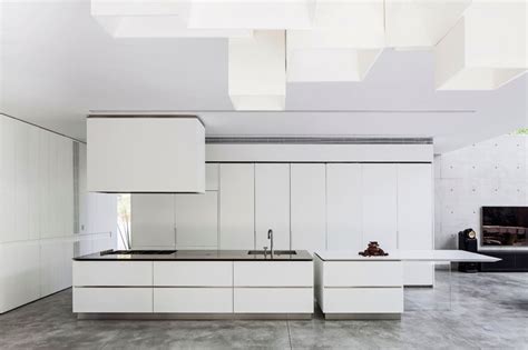 A modern whitewashed space with whitwashed brick walls and a sloped ceiling and. Kitchen Design Idea - White, Modern and Minimalist Cabinets