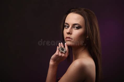 Beautiful Brunette Woman With Professional Makeup And Hairstyle Showing Big Ring In Mouth And