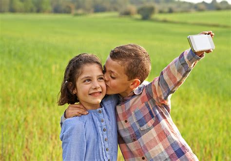 Siblings Taking Selfie In Green Field By Guille Faingold