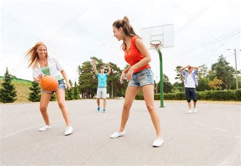 Group Of Happy Teenagers Playing Basketball Stock Photo By ©syda