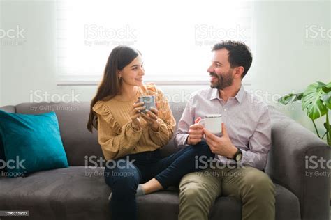 Hispanic Husband And Wife Enjoying A Cup Of Tea In The Living Room