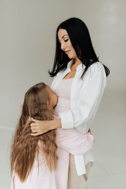 Premium Photo Beautiful Brunette Mom Hugs Her Daughter With Long