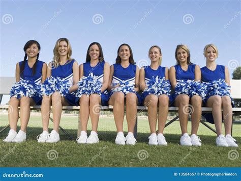 Cheerleaders Sitting With Legs Crossed At Knee On Field Stock Image