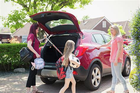Lesbian Couple And Daughter Loading Car For School Photograph By Caia