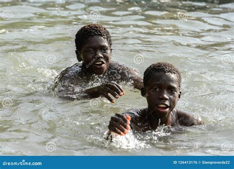 Unidentified Local Boys Swim In Water During A High Tide Editorial