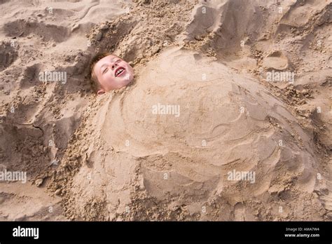 Uk Dorset Swanage Beach Child Buried Up To Neck In The Sand Stock Photo