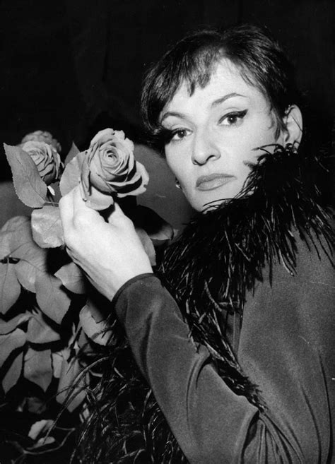 A Woman Holding A Rose In Her Right Hand And Looking At The Camera