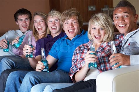 Group Of Teenage Freunde Sitzen Auf Sofa Zu Hause Vor Dem Trinken Alkohol Stockfoto Colourbox