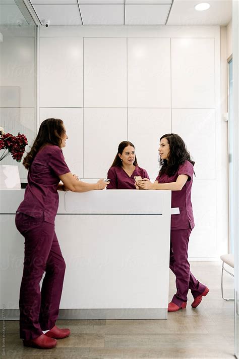 Conversation Between Doctor And Nurses In Hallway By Stocksy