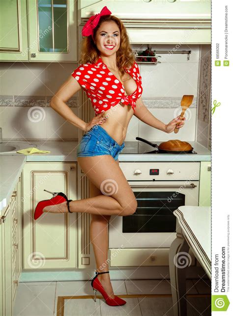 Smiling Charming Girl In Clothes Pin Up Prepares The Kitchen Stock