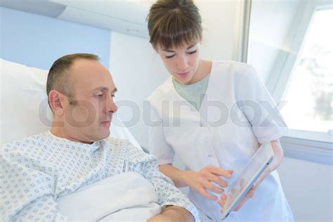 Female Nurse Takes Care Of Man In Bed Stock Image Colourbox