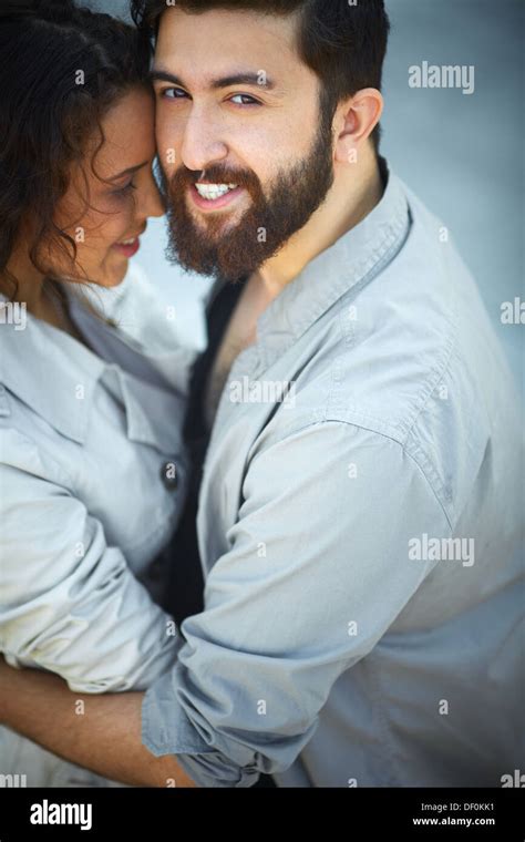 Image Of Happy Man Looking At Camera While Embracing His Sweetheart