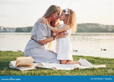 feliz madre joven con una hija juguetona en un parque cerca del agua foto de archivo imagen de